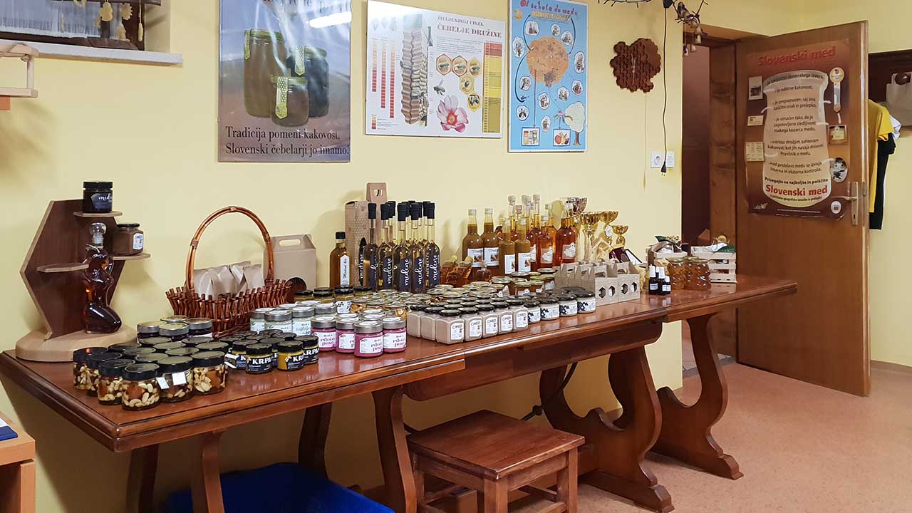 Miza s kozarci medu in steklenicami likerja