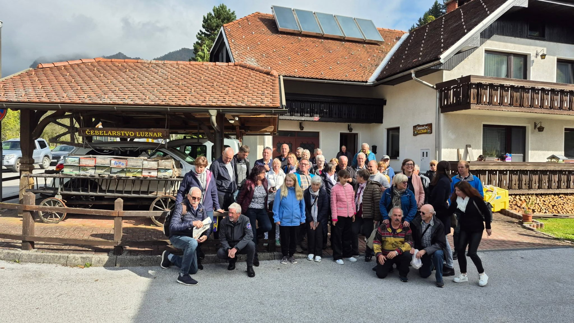 Skupinska fotografija obiskovalcev pred domačijo Luznar